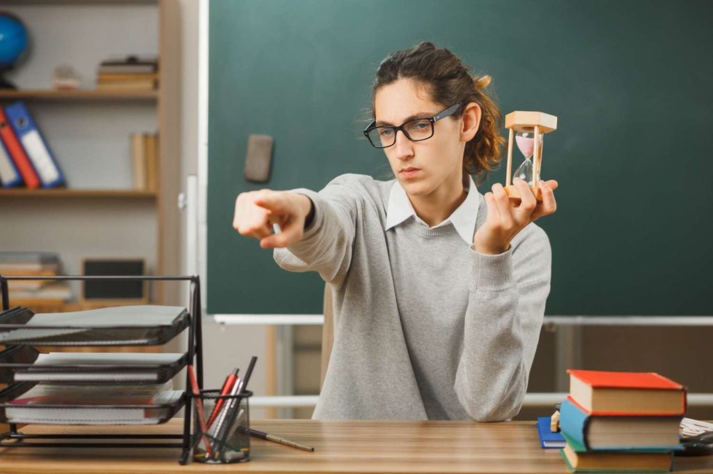 how to build self discipline as a student - focused student holding hourglass managing time in classroom