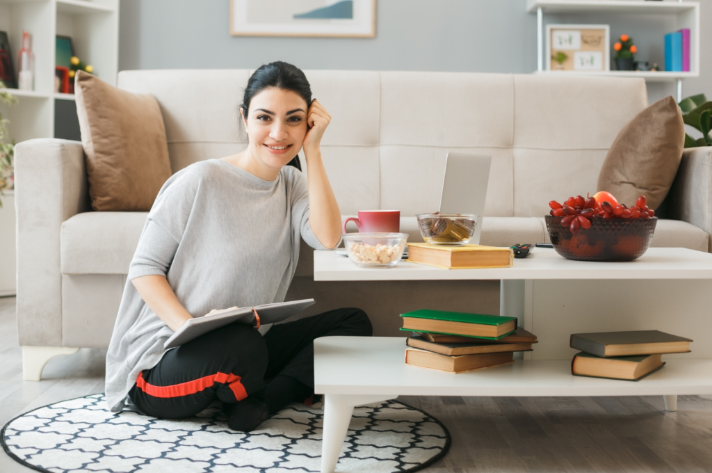 micro habits for women - young woman sitting at home with book and laptop practicing daily self improvement habits